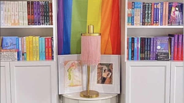 A Pride Flag surrounded by bookshelves.